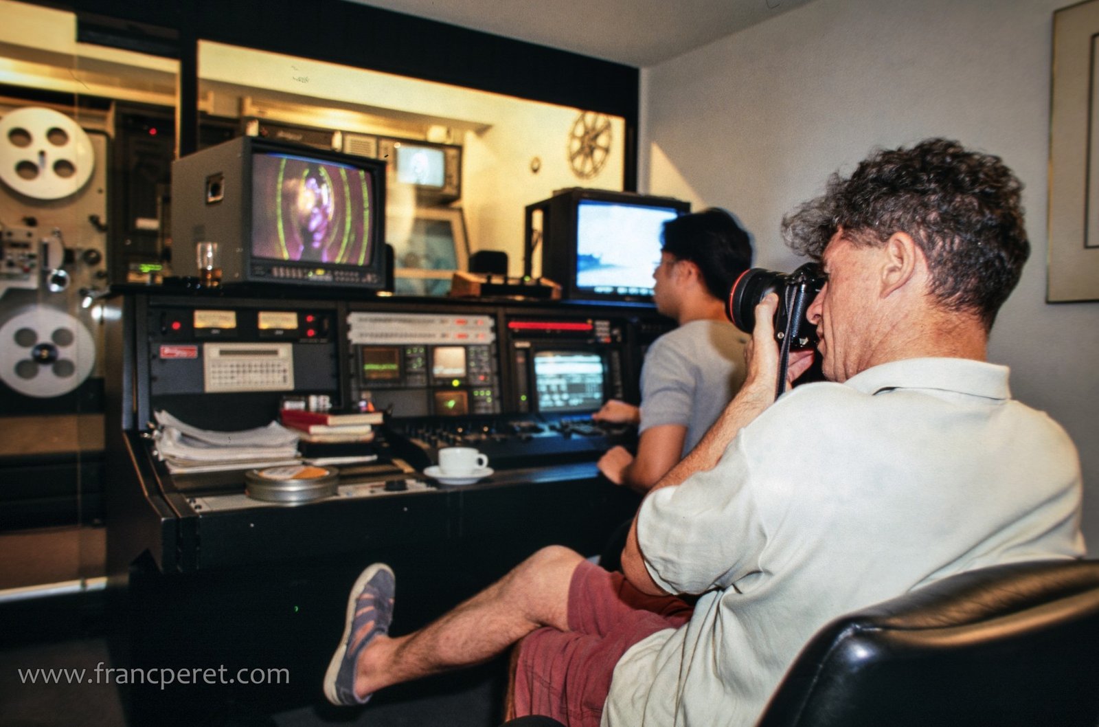 Christopher Doyle shooting still picture while monitoring the editing of a TV commercial.