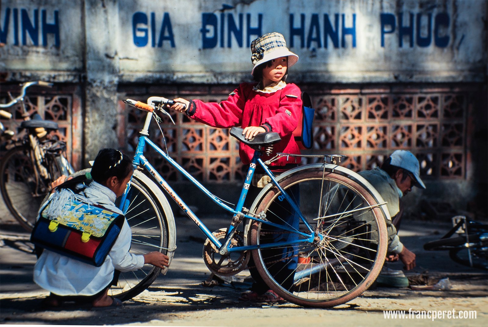 Schoolgirls repairing their bicycle