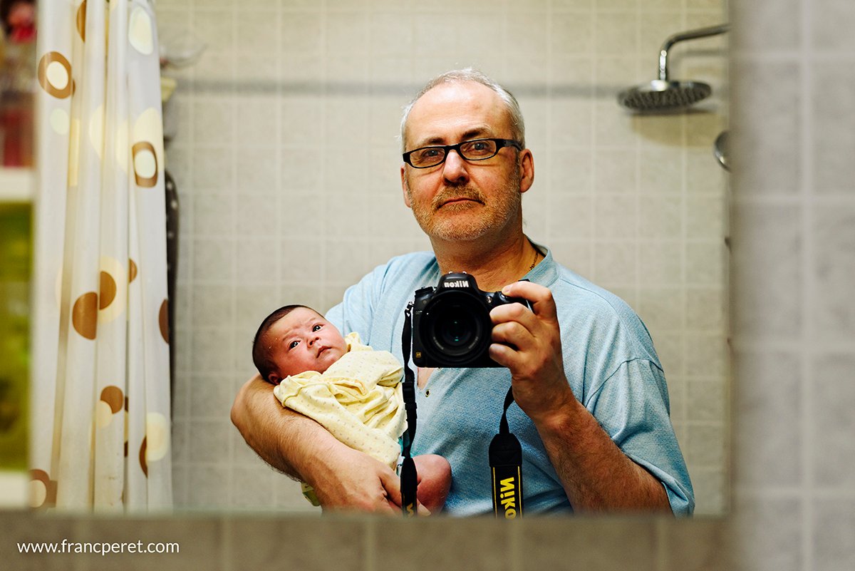Auto portrait in the bathroom. First of all, light on as many (and good) lights as possible to get a better quality shot. Photography is painting with light! Second, position the focus point on something significant (such as a face), hold the camera firmly (and the baby too!) and try to keep it straight, horizontal and stable. Nikon D750 ISO400 1/80s and 50mm f1.8 @ f2.8. I increased the ISO a bit to be able to close down the Aperture (to get more DOF) as my face and baby's face are not on the exact same distance. As I am stable to hold the camera and to not move, 1/80s was sufficient.