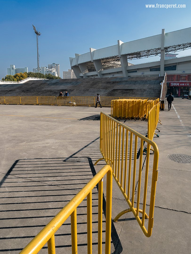 The diverse structures (barrier, steps, wall, stadium...) the strong shadow and the presence of the 2 opposite colors (yellow and blue) attracted my B&W vision.